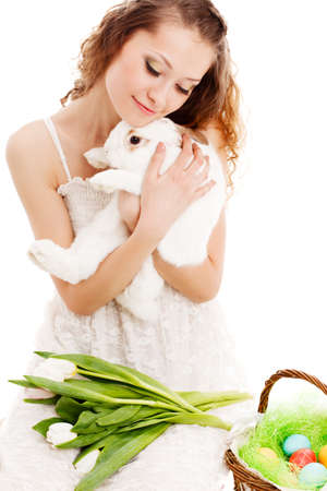 closeup happy woman sitting on the floor with tulips and a rabbitの写真素材