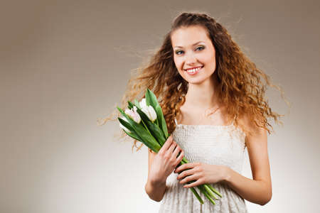 happy beautiful smiling woman holding tulips, gradient backgroundの写真素材