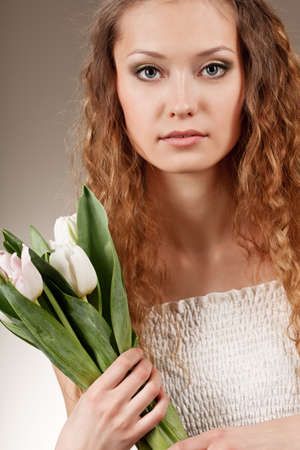 girl with curly hair holding a bucket of white tulipsの写真素材