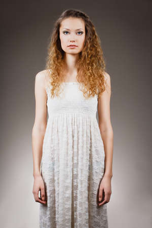 beautiful curly haired woman standing strait portraitの写真素材