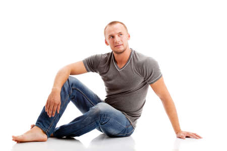 strong casually dressed man over white background sitting on the floorの写真素材