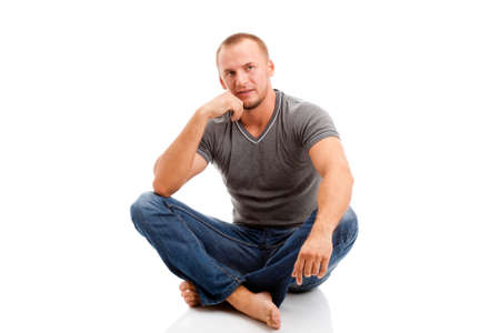 strong casually dressed man over white background sitting on the floorの写真素材