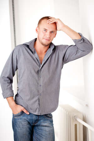 strong casually dressed man near white wallの写真素材