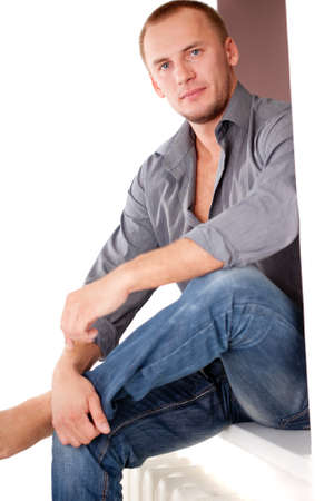 strong casually dressed man sitting on sillの写真素材