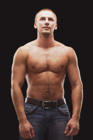 strong musculine man posing shirtless over black background, loking upの写真素材