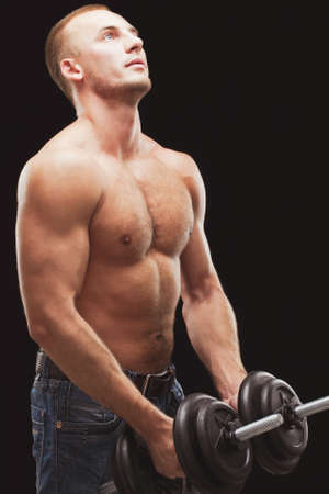 strong man excersizing with heavy dumbbells over black backgroundの写真素材