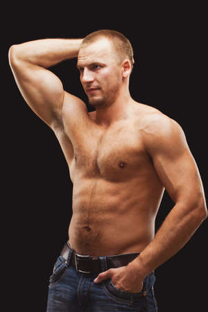 strong musculine man posing shirtless over black backgroundの写真素材