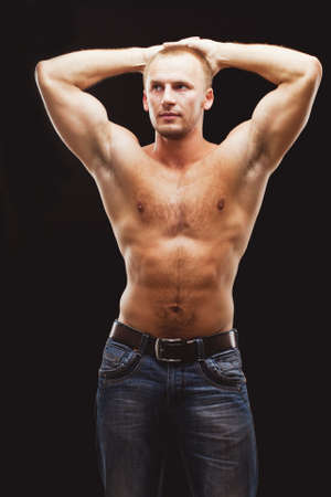 strong musculine man posing shirtless over black backgroundの写真素材