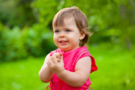 little girl counting her fingers in the parkの写真素材