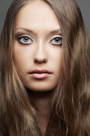 closeup beautiful woman face portrait over gray backgroundの写真素材