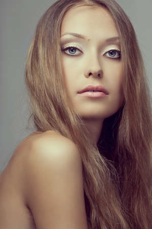 beautiful woman face portrait over gray background, toned photographyの写真素材