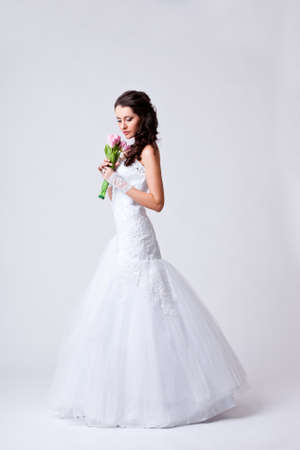 beautiful bride holding bouquet studio full length portraitの写真素材