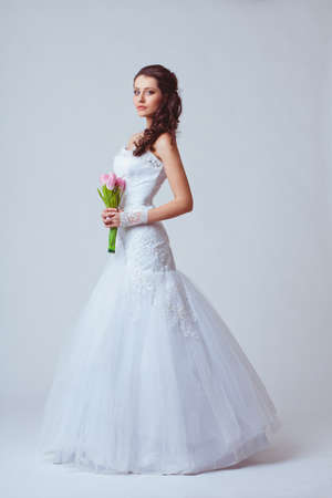beautiful bride holding bouquet studio full length portrait, toned imageの写真素材