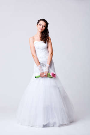 beautiful bride holding bouquet studio full length portraitの写真素材