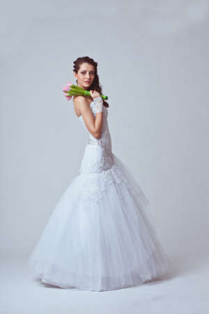 beautiful bride holding bouquet studio full length portraitの写真素材