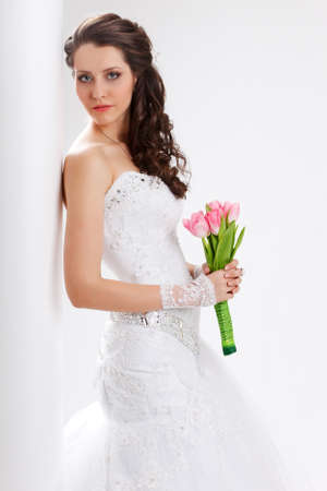 beautiful bride standing back to the  white column, studio shotの写真素材