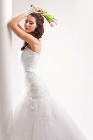 beautiful bride rests her elbows on a white columnの写真素材