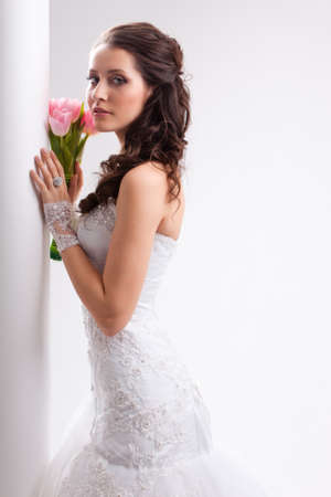 beautiful bride standing near white column, studio shotの写真素材
