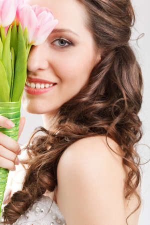 closeup smiling bride face portrait with flowers bouquetの写真素材