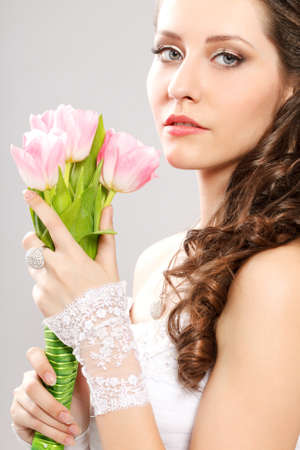 bride studio closeup portrait with bouquet of pink tulipsの写真素材