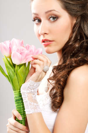 surprised bride studio portrait with bouquet of pink tulipsの写真素材
