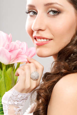 closeup  bride face studio portrait with bouquet of pink tulipsの写真素材
