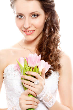 smiling bride studio portrait with bouquet of pink tulipsの写真素材
