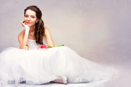 smiling beautiful brunette  bride sitting on the floor, vintage style photoの写真素材