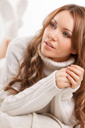 beautiful sexy woman wearing sweater lying on the sofaの写真素材