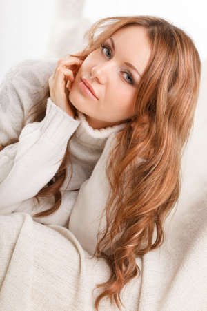 beautiful sexy woman wearing sweater lying on the sofaの写真素材