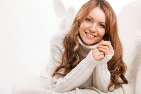 beautiful sexy woman wearing sweater lying on the sofaの写真素材