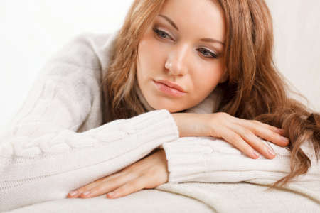 beautiful sexy woman wearing sweater lying on the sofaの写真素材