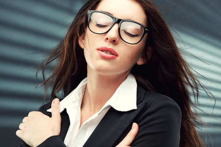 close-up portraits of a businesswoman with closed eyes and flying hairの写真素材