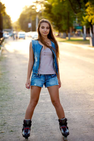 teenager girl skating outdoors  during sunsetの写真素材