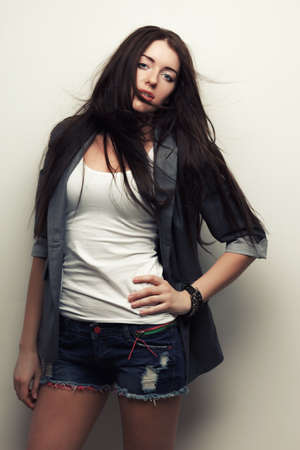woman fashion studio portrait with flying hair over white wallの写真素材
