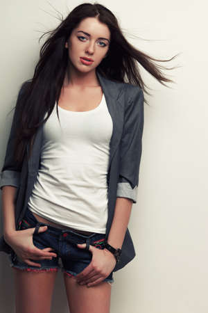 woman fashion studio portrait with flying hair over white wallの写真素材