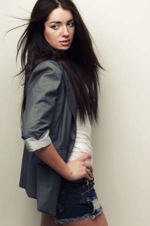 woman fashion studio portrait with flying hair over white wallの写真素材