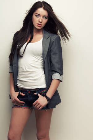 woman fashion studio portrait with flying hair over white wallの写真素材
