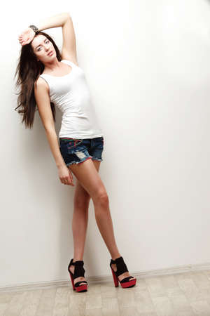 woman fashion studio portrait with hand on head , posing over wallの写真素材