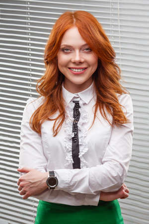 red-haired businesswoman standing over blindsの写真素材