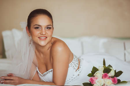 beautiful bride portrait lying on bed indoorsの写真素材