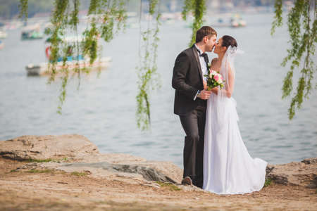 beautiful lovely bridal couple standing near lake, horizontal photoの写真素材