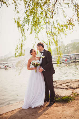 beautiful lovely bridal couple standing near lakeの写真素材