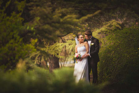 happy bridal couple walking in parkの写真素材