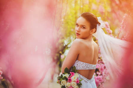 beautiful bride portrait over pink cherry trees outdoorの写真素材