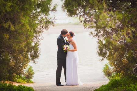 bride and groom outdoors park under trees arcの写真素材
