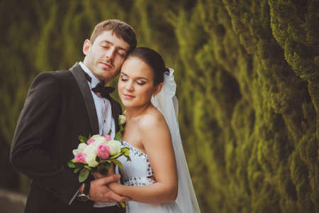 bride and groom with closed eyes outdoors portraitの写真素材