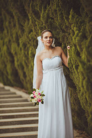 beautiful bride closeup portrait over green trees outdoorの写真素材