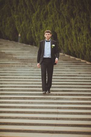 groom walking down  on staircaseの写真素材