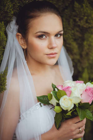 beautiful bride closeup portrait over green trees outdoor, verticalの写真素材